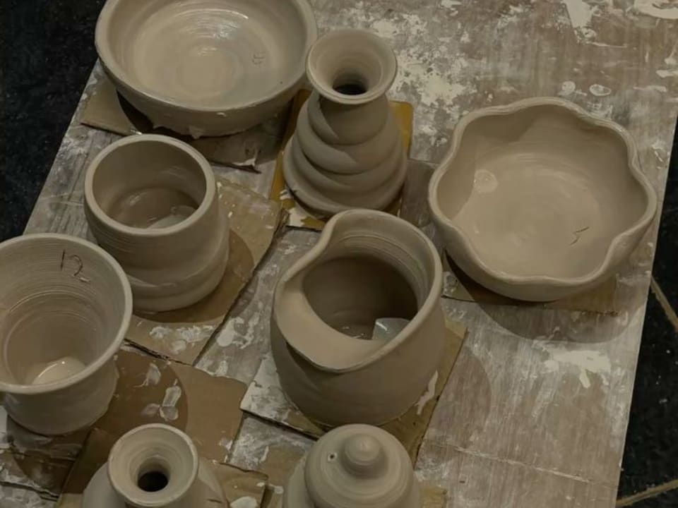Unfired pots waiting on a workshop board